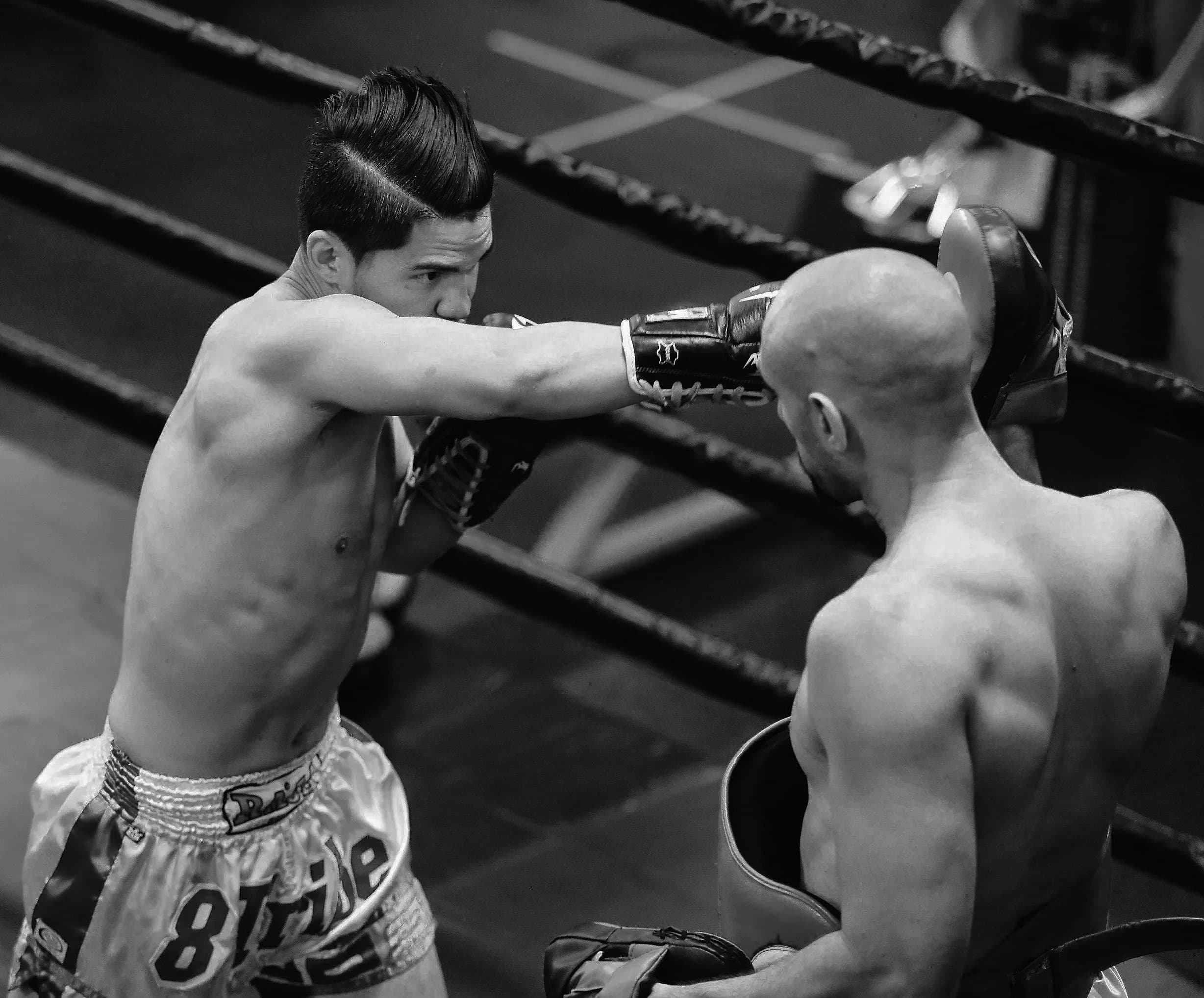 Student throwing a straight punch into Ronnie's pads